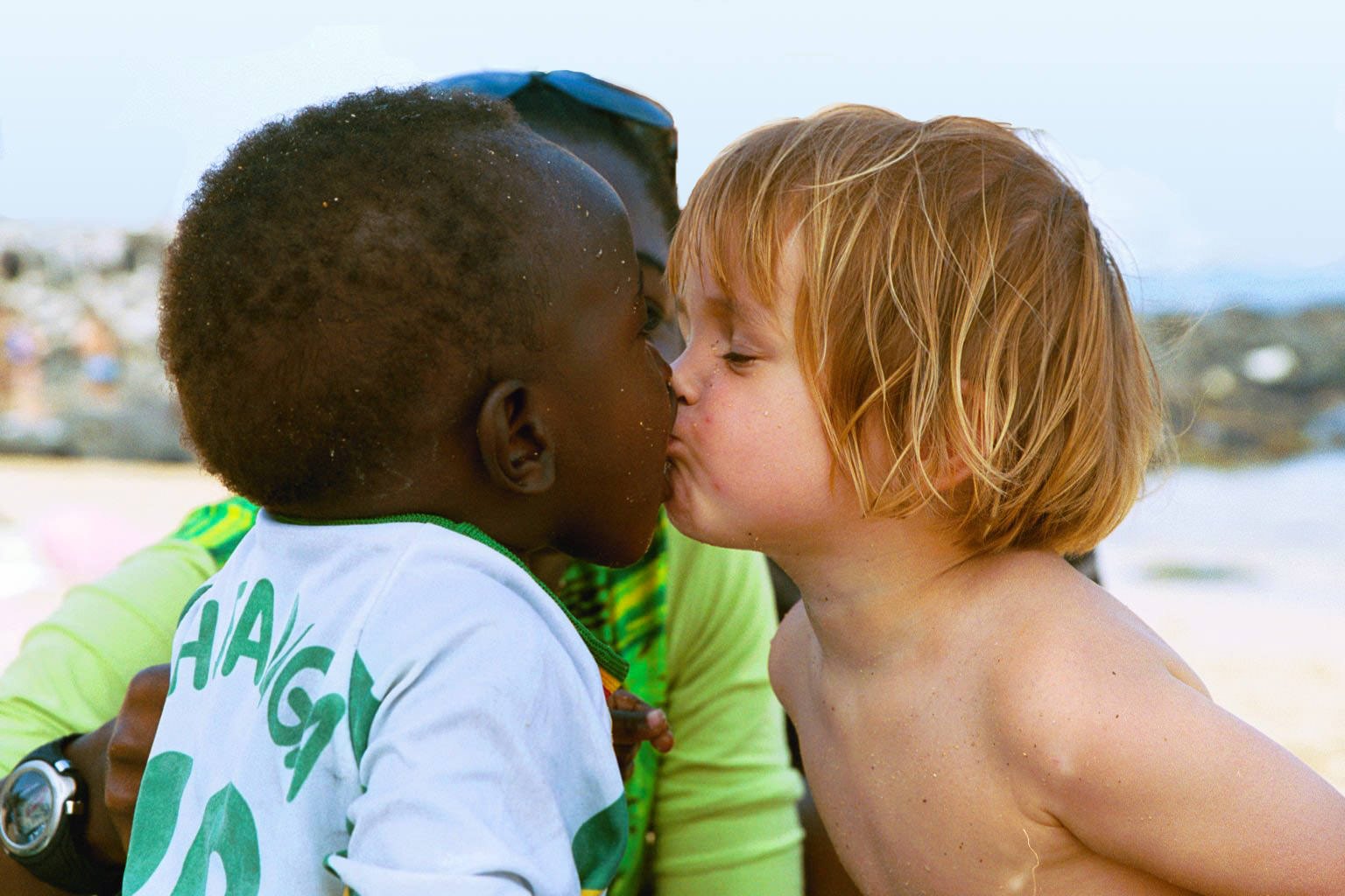 Two children kissing on a beach